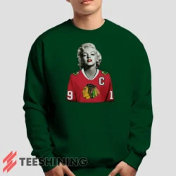 Male model lounging in the Marilyn Monroe Chicago Blackhawks Unique Hockey Fan Men's Sweatshirt in forest green. Made from ultra-soft fabric for unmatched comfort.