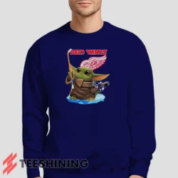 Male model lounging in the Star Wars Baby Yoda Detroit Red Wings Fun NHL Sci - Fi Fan Men's Sweatshirt in navy. Made from ultra-soft fabric for unmatched comfort.