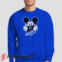 Male model lounging in the Vegas Golden Knights Haters Gonna Hate Mickey Mouse Disney Hockey Men's Sweatshirt in royal blue. Made from ultra-soft fabric for unmatched comfort.