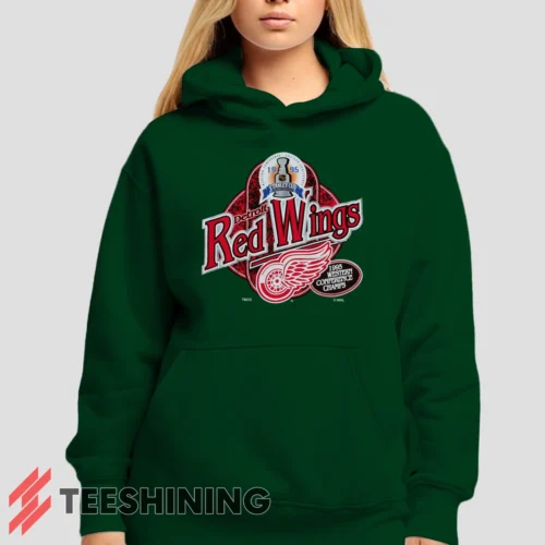 Female model showcasing the 90s Detroit Red Wings Western Conference Champs Vintage Hockey Fan Women's Hoodie in forest green. This ultra-cozy pullover hoodie is designed for warmth and everyday versatility.