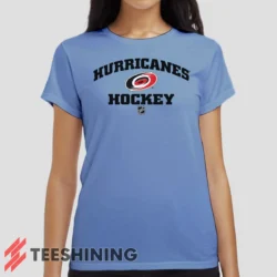 Female model wearing the Carolina Hurricanes NHL Hockey Women's T-Shirt in light blue. Crafted from ultra-soft cotton, this classic crew neck tee offers breathable comfort and effortless style.