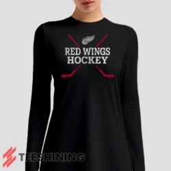 Female model sporting the Detroit Red Wings Hockey Women's Long Sleeve T-Shirt in black. Lightweight and breathable, ideal for transitional weather.