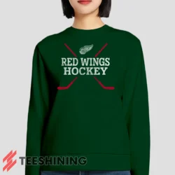 Female model lounging in the Detroit Red Wings Hockey Women's Sweatshirt in forest green. Made from ultra-soft fabric for unmatched comfort.