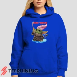 Female model showcasing the Star Wars Baby Yoda Detroit Red Wings Fun NHL Sci - Fi Fan Women's Hoodie in royal blue. This ultra-cozy pullover hoodie is designed for warmth and everyday versatility.