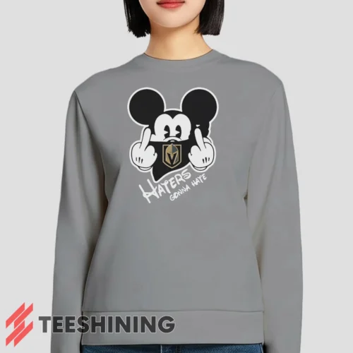 Female model lounging in the Vegas Golden Knights Haters Gonna Hate Mickey Mouse Disney Hockey Women's Sweatshirt in sport grey. Made from ultra-soft fabric for unmatched comfort.